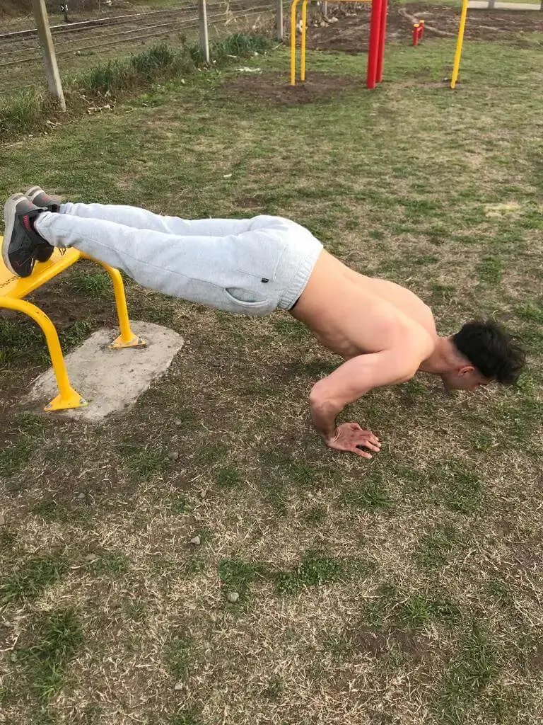 Flexiones declinadas de calistenia para hombros y pecho.