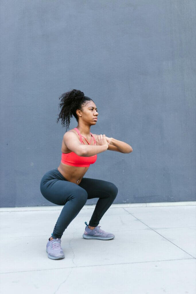 Sentadillas, ejercicio que se puede incluir en una rutina para glúteos en casa.