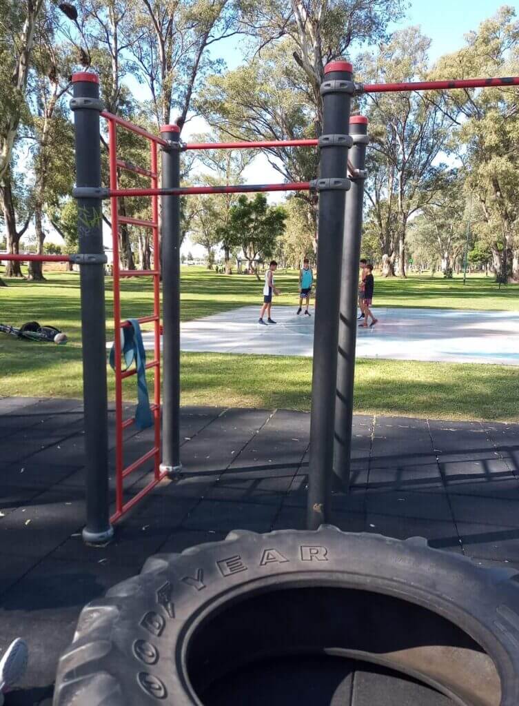 parque de calistenia con una rueda de tractor en primer plano