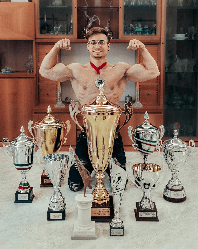 andrea larosa posando ante los trofeos