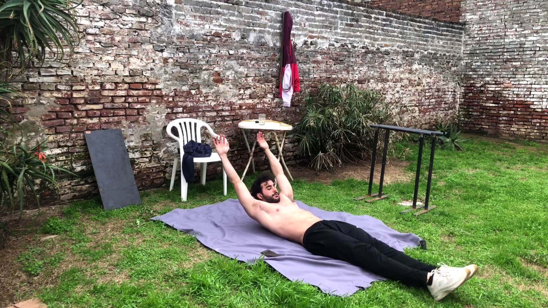 Eleva los brazos por encima de la cabeza, fase dos del hollow body.