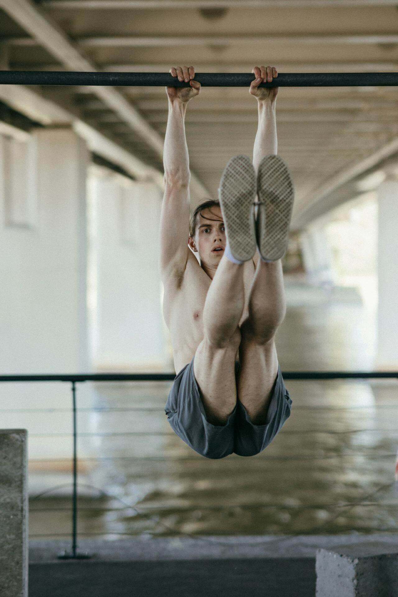 Haaciendo la fase concéntrica de un toes tobar o pies a la barra ejercicio de calistenia para abdominales.